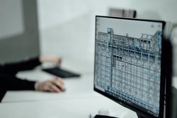 BIM on a computer screen with a person sitting at a desk.