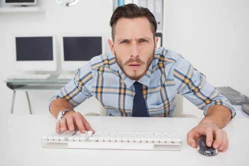 Focused casual businessman working at his desk in his office

