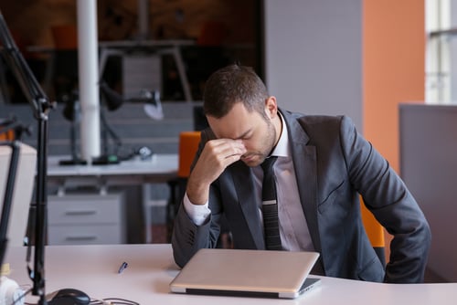 frustrated young businessman working on laptop computer at office.
