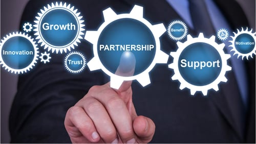 Digital wheels with a man pointing at them with the words "partnership" in the wheel