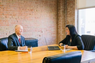 man and woman sitting at a conference table at work