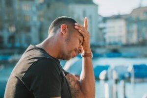 Man with one hand pressed to his forehead in an exasperated gesture