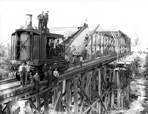 1922 black and white photo of men on a locomotive crane during bridge construction