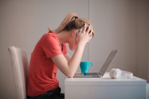 woman sitting at a desk with her head in her hands