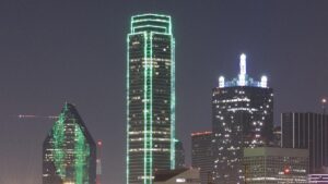 a skyscraper outlined in green lighting at night
