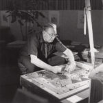 black and white photo of architect Bruce Goff working on a mosaic