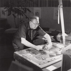 black and white photo of architect Bruce Goff working on a mosaic
