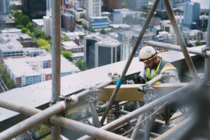 man wearing a hardhat working on a high-rise skyscraper