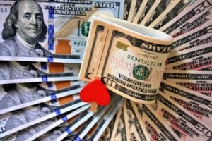 ten dollar bill on top of several one hundred dollar bills