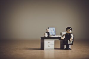 lego man at desk looking sad