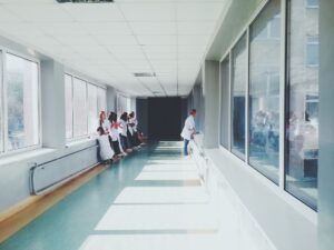a hospital hallway with a group of doctors looking out the window