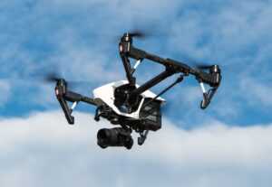 black and white drone against a blue sky and clouds