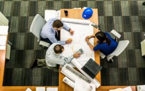 three people sitting at a small conference table