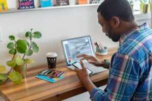 Man sitting at desk with laptop and mobile phone