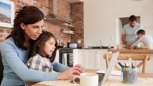 woman working from home on a laptop with a child in her lap