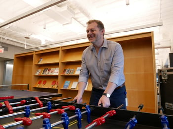 Beck Technology team member happily playing foosball in the Beck Technology office. 
