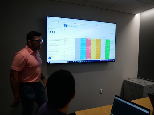 A Beck Technology sales team member demonstrating DESTINI Bid Day on a large computer monitor. 