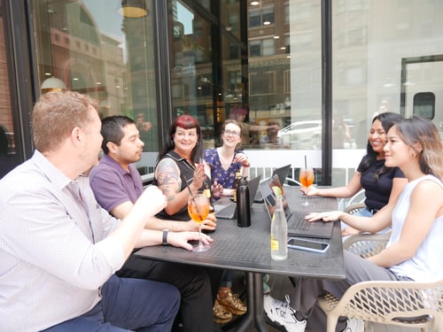 Members of the Beck Technology team socialize at a coffee shop outside the Beck Technology office in downtown Dallas, Texas. 
