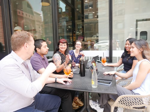 Members of the Beck Technology team socialize at a coffee shop outside the Beck Technology office in downtown Dallas, Texas.