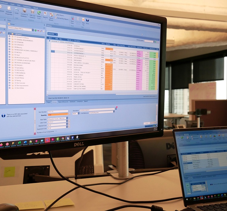 Monitor showing DESTINI Estimator in office.