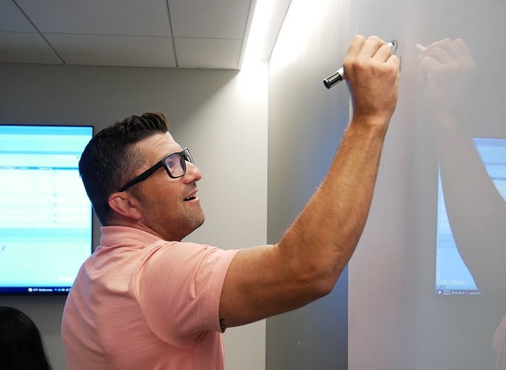 Man writing on a whiteboard.